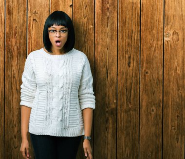 Güzel genç Afro-Amerikan kadın korkuyor ve şok sürpriz ifade, korku ve heyecan yüz ile izole arka plan üzerinde gözlük.