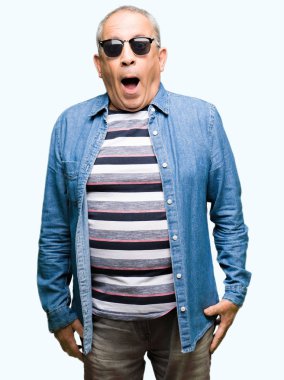 Üst düzey yakışıklı denim ceket ve güneş gözlüğü korkuyor ve sürpriz ifade, korku ve heyecan yüz ile şok.