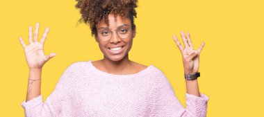 Güzel genç Afro-Amerikan kadın gözlük gösterilen ve parmakları ile işaret izole arka plan üzerinde dokuz kendinden emin ve mutlu gülümseyerek iken numara.