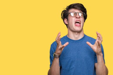 Üzerinde gözlük takan genç yakışıklı adam arka plan deli izole ve deli bağırarak ve agresif ifade ve silah kaldırdı bağırıyor. Hayal kırıklığı kavramı.