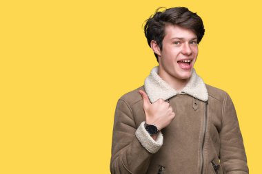 Genç yakışıklı adam el ile jest kadar mutlu başparmak yapıyor izole arka plan üzerinde kış ceket giyiyor. Başarı gösteren kameraya bakarak ifadeyi onaylama.