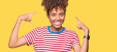 Her ikisi ile baş gösteren gülen eller güzel genç Afro-Amerikan kadın izole arka plan üzerinde parmak, harika bir fikir ya da düşünce, iyi hafıza