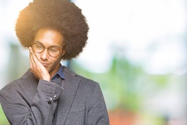 Afro saçlı gözlüklü seyir yorgun ve çapraz kolları olan depresyon sorunları ile sıkılmış düşünme genç Afro-Amerikalı iş adamı.