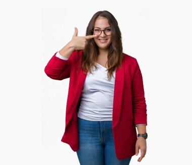 Güzel artı boyutu genç iş kadını giyen şık ceket ve gözlük izole üzerinde işaretleme için yüz ve burun, neşeli gülümseyerek el parmak ile arka plan
