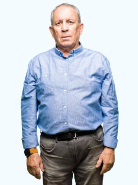 Yakışıklı üst düzey businesss adam yüzünde ciddi bir ifade ile şık gömlek giymiş. Basit ve doğal kameraya bakıyor.