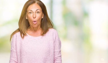 Güzel orta yaş yetişkin kadın giyiyor kış kazak korkuyor ve şok sürpriz ifade ile izole arka plan üzerinde korku ve yüz heyecanlı.