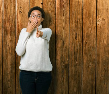 Genç güzel Afrikalı-Amerikalı kadın gözlük izole üzerinde gülme sizin parmak el kamerasıyla ağzına, utanç ifadesi işaret eden arka plan