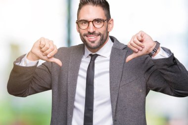 Genç yakışıklı iş adamı yüzünde gülümseme ile kendinden emin görünüyorsun, kendini gururlu ve mutlu parmakları ile işaret izole arka plan üzerinde.