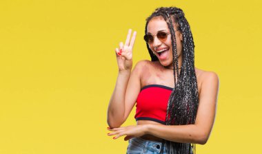 Mutlu yüz zafer işareti yaparken kameraya göz kırpıyor ile gülümseyen izole arka plan üzerinde güneş gözlüğü takıyor Doğum işareti ile saç Afrikalı-Amerikalı genç örgülü. İki numaralı.