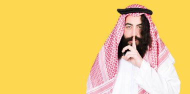 Arap iş adamı dudaklarında parmak ile sessiz olmanı geleneksel keffiyeh eşarp uzun saçlı. Sessizlik ve gizli kavramı.
