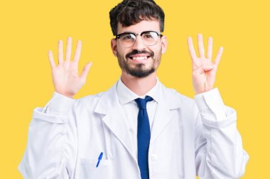 Gösterilen arka plan üzerinde beyaz önlük giyen genç profesyonel bilim adam izole ve parmakları ile işaret numara 9 kendinden emin ve mutlu gülümseyerek süre.