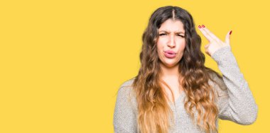 Genç güzel kadın giyiyor kış giysi çekim ve öldürmek kendini kafasına el ve parmak işaret, intihar jest.