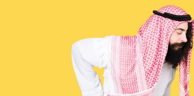 Arap iş adamı uzun saç giyen geleneksel keffiyeh ile el ile geri, kas ağrısı dokunmadan acı sırt ağrısı, eşarp