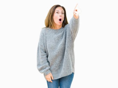 Güzel orta yaş kadın giyiyor kış kazak izole arka plan ile sürpriz devam et, parmakla üzerinde açık ağız ifade, önünde bir şey hayret