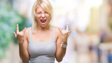 Genç güzel sarışın kadın deli ifade rock simge elle yapıyor ile bağırarak izole arka plan yüzünden. Müzik yıldızı. Ağır kavramı.