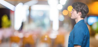 Genç yakışıklı adam gözlük izole arka tarafına, seyir üzerinde dinlenmek doğal yüz emin gülümseme ile pozuyla profili.