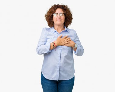 Güzel orta ager üst düzey businees kadın kapalı gözler ile göğüs ellerinde ve yüzünde minnettar jest ile gülümseyen izole arka plan üzerinde gözlük takıyorum. Sağlık kavramı.