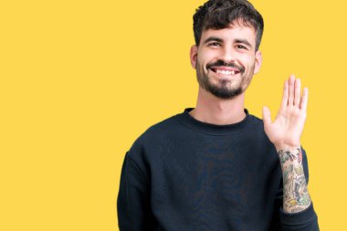 Yakışıklı delikanlı izole arka plan Waiving mutlu selam söyleyerek üzerinde ve gülümseyen, dostça karşılama jest
