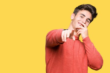 İzole genç yakışıklı adam arka plan sizin parmak el kamerasıyla ağzına, utanç ifadesi işaret eden gülme