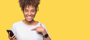 Sürpriz yüz işaret parmağı kendini izole arka plan üzerinde akıllı telefon kullanan genç Afro-Amerikan kadın