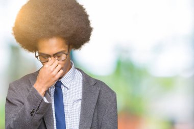 Gözlük yorgun sürtünme burun ve göz yorgunluğu ve baş ağrısı duygu afro saçlı genç Afro-Amerikalı iş adamı. Stres ve hayal kırıklığı kavramı.