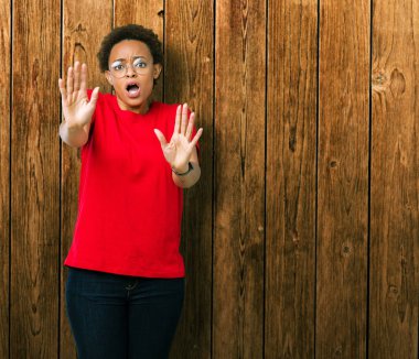 Güzel genç Afro-Amerikan kadın üzerinde gözlük takan şokta bağırarak arka plan korkuyor ve dehşet korku ifade dur hareketi el ile ile izole. Panik kavramı.