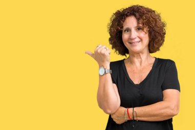 Seyir ve başparmak yanında yukarıyı mutlu yüz ile gülümseyen izole arka plan güzel orta ager üst düzey kadın.