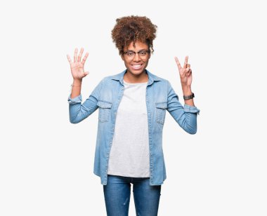 Güzel genç Afro-Amerikan kadın gözlük gösterilen ve parmakları ile işaret izole arka plan üzerinde kendinden emin ve mutlu gülümseyerek süre yedi numara.