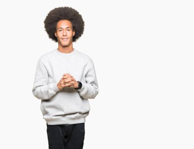 Afro saçlı sportif kazak eller birlikte giyen ve parmakları genç Afro-Amerikan adam rahat ve neşeli gülümseyen geçti. Başarı ve iyimser