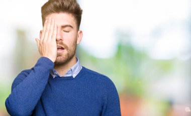 Genç yakışıklı bussines adam yarım yüz, göz ve ağız el ile kapsayan yorgun esneme. Acı yüzü acıyor.