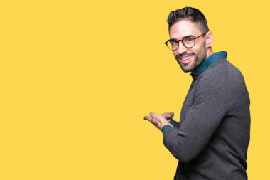 Açık el ile doğal gülümseyen girmek için davet izole arka plan üzerinde gözlük takan genç yakışıklı adam