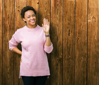 İzole arka plan Waiving Merhaba mutlu güzel genç Afrikalı-Amerikalı kadın ve gülümseyen, dostça karşılama jest