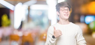 Hareketi el ile mutlu yaşasın yapıyor izole arka plan üzerinde gözlük takan yakışıklı delikanlı. Başarı gösteren kameraya bakarak ifade onaylama.