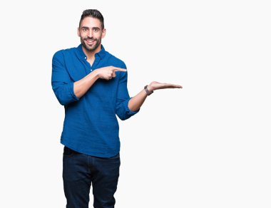 Yakışıklı delikanlı üzerinden hayran ve el ile sunulması ve parmak ile işaret ederken kameraya gülümseyen izole arka plan.