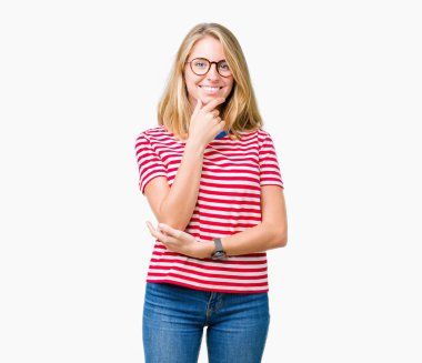 Emin çapraz kollar ve çeneme kaldırdı el ile gülümseme ile kameraya bakarak izole arka plan üzerinde gözlük güzel ve genç birbayan. Pozitif düşünce.