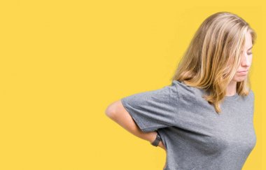 Büyük boy rahat t-shirt üzerinde izole giyen güzel genç kadın acı dokunmadan el ile geri, kas ağrısı, sırt ağrısı, arka plan