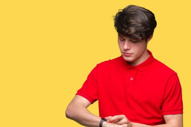 Kol saati, rahat ve kendinden emin zamanında kontrol izole arka plan üzerinde kırmızı t-shirt giyen genç yakışıklı adam