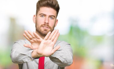 Genç yakışıklı iş adamı ret ifade geçiş silah ve avuç içi eksi işareti, kızgın surat yapıyor