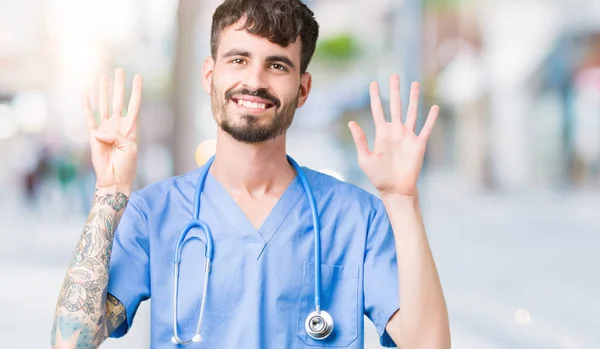 잘생긴 간호사 배경에 보여주는 유니폼을 남자와 자신감과 손가락으로 가리키는 — 스톡 사진