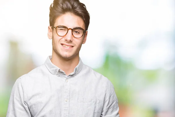 Joven Hombre Guapo Con Gafas Sobre Fondo Aislado Guiño Mirando —  Fotos de Stock