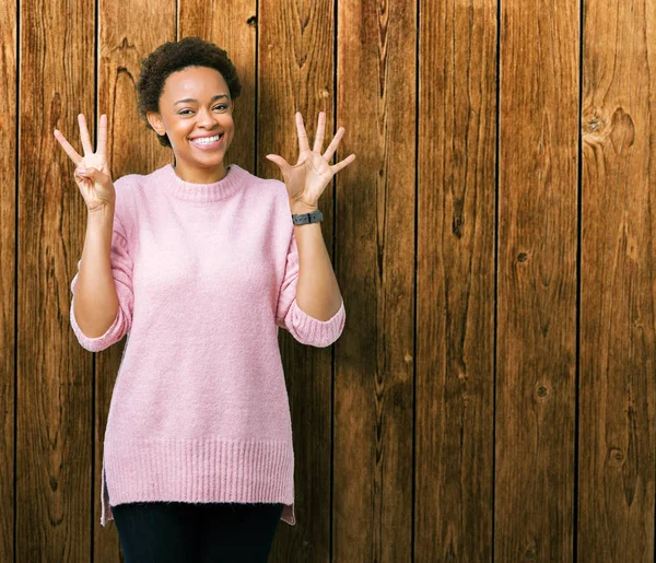 Güzel genç Afro-Amerikan kadın gösterilen ve parmakları ile işaret izole arka plan yüzünden kendinden emin ve mutlu gülümseyerek süre 8 numaralı.