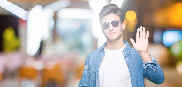 Junger Gutaussehender Mann Mit Sonnenbrille Über Isoliertem Hintergrund Der Auf — Stockfoto