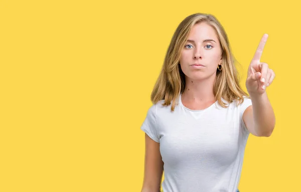 分離でカジュアルな白い シャツを着ての美しい若い女性を指と怒りの表現のポインティングを背景します — ストック写真