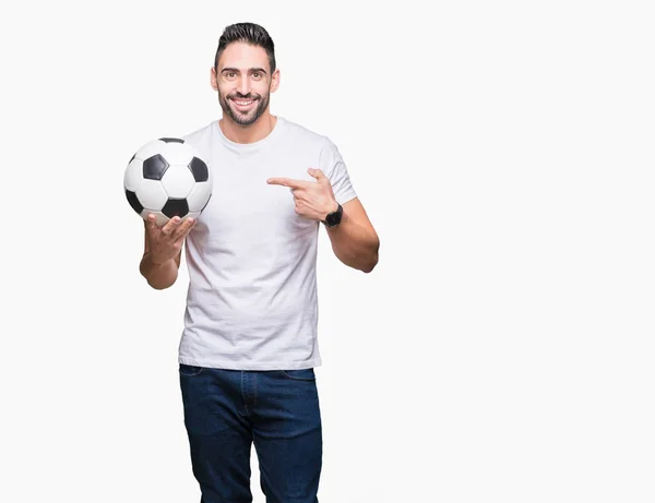 Молодой Человек Держащий Футбольный Мяч Изолированном Фоне Доволен Указывая Рукой — стоковое фото