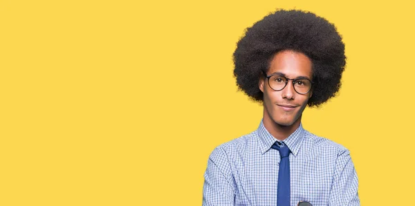 アフロの髪を身に着けているメガネの幸せそうな顔を浮かべて若いアフリカ系アメリカ人ビジネスマンは カメラを見て腕を交差しました 肯定的な人 — ストック写真