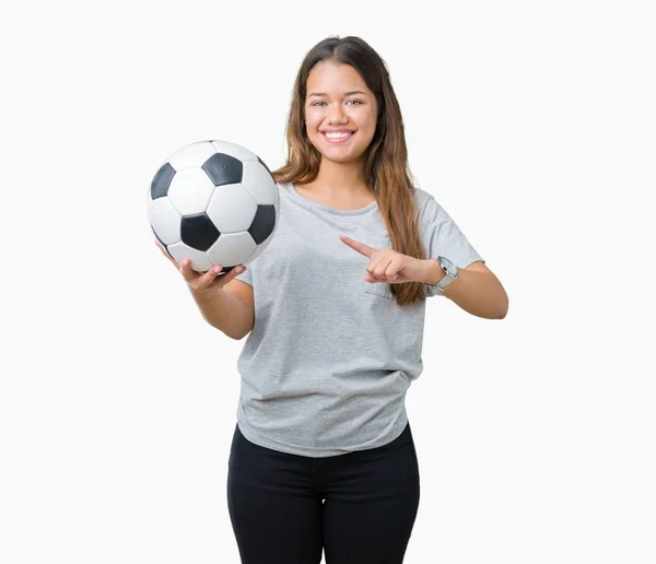 拿着足球足球在孤立的背景很高兴用手和手指指向年轻美丽的黑发妇女 — 图库照片
