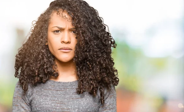 Joven Hermosa Mujer Con Pelo Rizado Usando Suéter Gris Escéptico —  Fotos de Stock