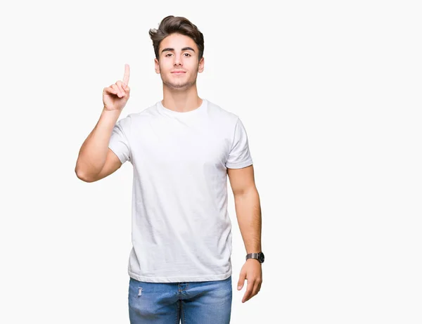 年轻英俊的男子穿着白色 T恤在孤立的背景显示和指向的手指第一 而微笑着自信和快乐 — 图库照片