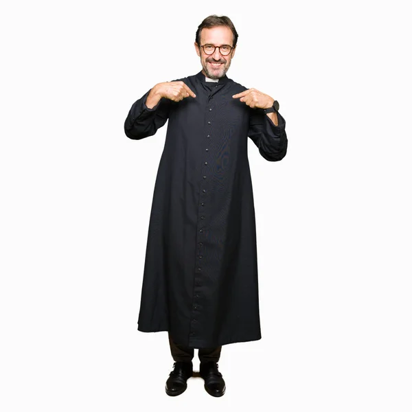 中年牧师男子穿着天主教长袍看自信 面带微笑 用手指指向自己骄傲和快乐 — 图库照片