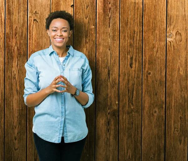 İzole arka plan el ele tutusun genç güzel Afrikalı-Amerikalı kadın ve rahat ve neşeli gülümseyen parmak çarpı işareti. Başarı ve iyimser